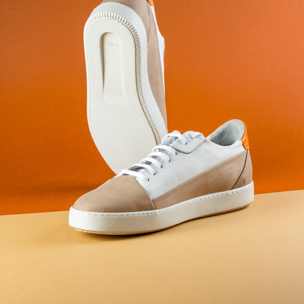 White beige sneakers on an orange background