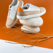 Preview picture of white beige sneakers on an orange background